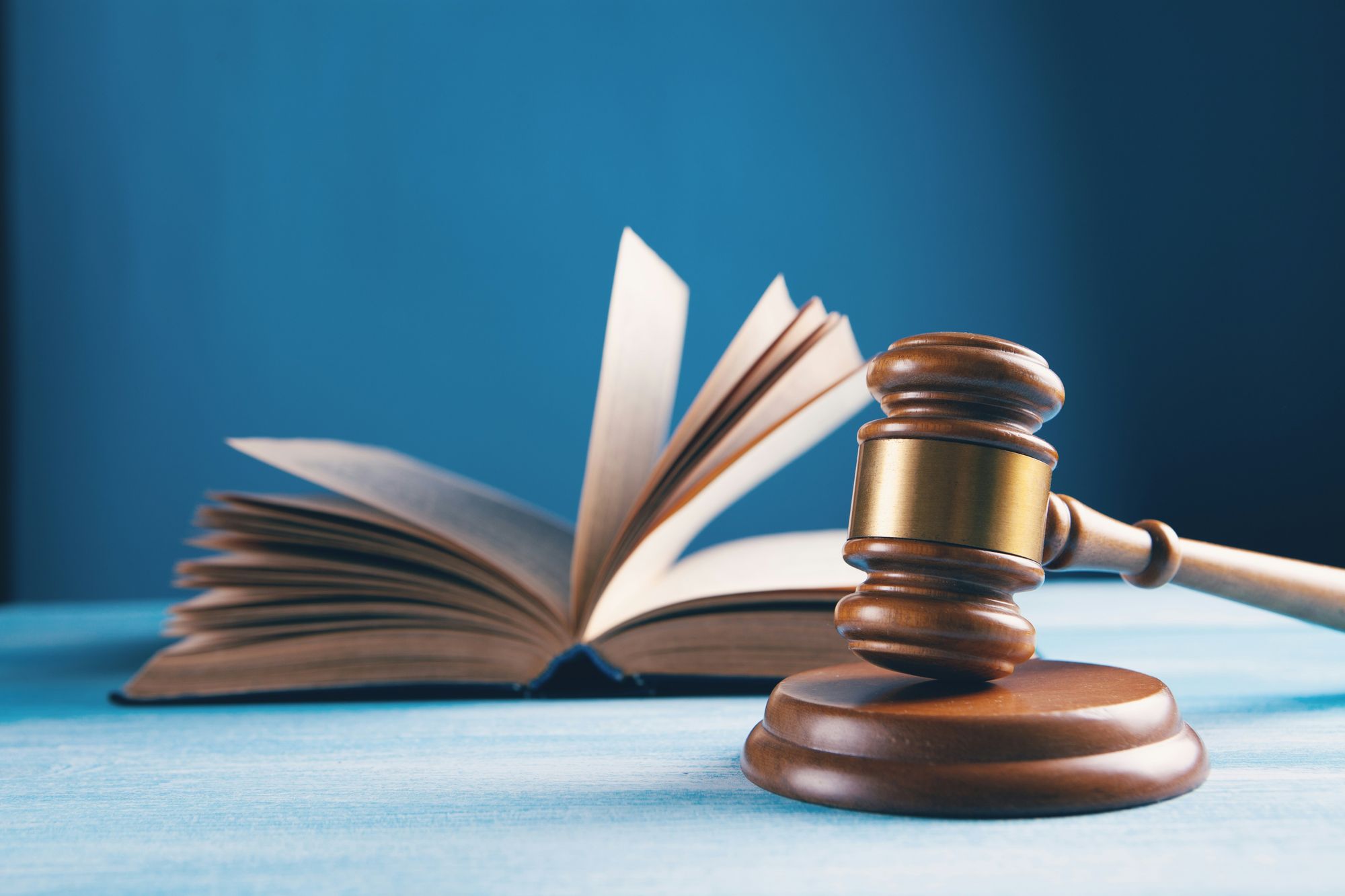 Ein Richterhammer liegt vor einem aufgeschlagenen Gesetzbuch – bereit, das eigene Recht durchzusetzen